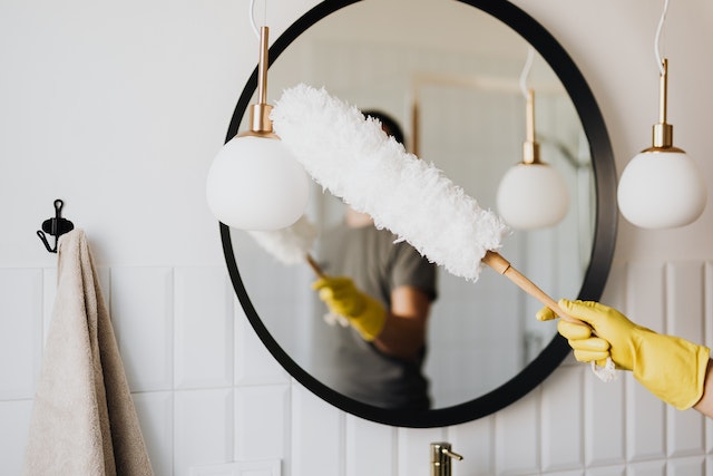 A person cleaning a mirror